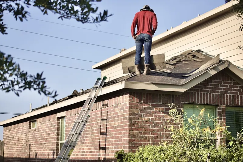Professional roofer working on a residential roof in Flat Creek